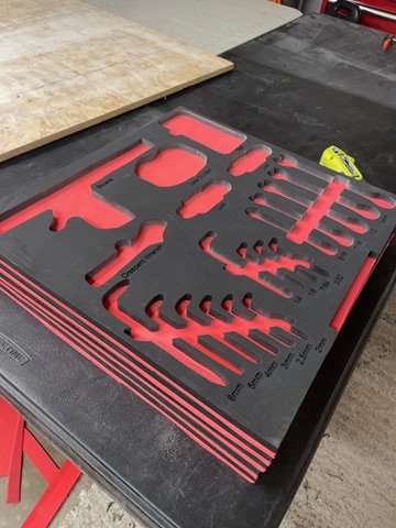 CNC-cut two-tone XLPE foam inserts laid out showing precision tool pockets ready for install
