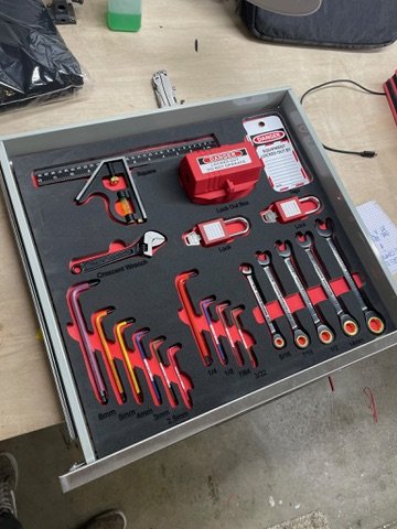 Overhead view of a completed TidyTool shadow board — hex keys, ratchets, crescent wrench, and lock-out kit fully seated in precision-cut pockets